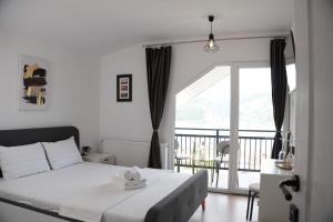 a bedroom with a white bed and a balcony at Casa Corina Dubova in Dubova +32 photos