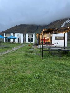 a house with a picnic table in the grass at Hotel Krebuli in Kazbegi +11 photos