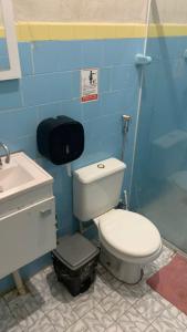 a bathroom with a white toilet and a sink at Hostel da Floresta in Vitória