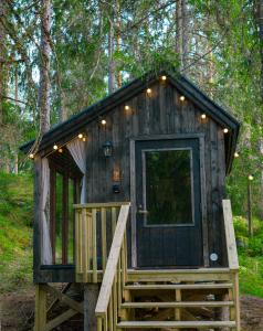 a wooden cabin with a staircase leading to the door at Minimökki Karjalohjalla in Lohja