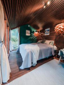 a bedroom with a large bed with a wooden ceiling at Minimökki Karjalohjalla in Lohja