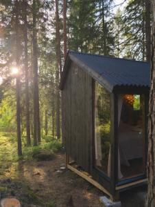 a small shed in the woods with a person inside at Minimökki Karjalohjalla in Lohja +30 photos