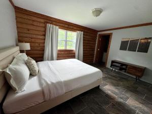 a bedroom with a white bed and a fireplace at The Shack in Oak Hill