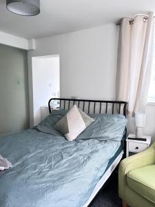 a bedroom with a bed with blue sheets and a window at Myrtle Villas in Hull