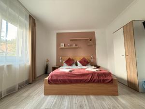 a bedroom with a large bed with a red blanket at Balaton Bloom Vendégház in Siófok