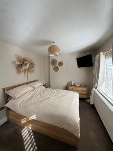 a bedroom with a large bed and a television at Harehills House in Killingbeck