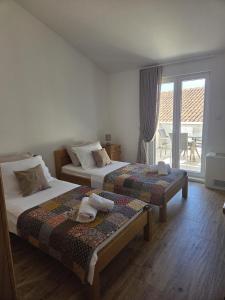 a bedroom with two beds and a balcony at Guest house Jere Old Town in Rogoznica