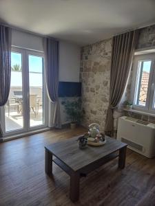 a living room with a table and a view of a patio at Guest house Jere Old Town in Rogoznica