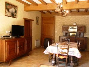 a dining room with a table and a tv at Maison lacabane in Saint-Sever +6 photos