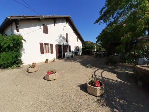 a white house with three baskets of flowers in it at Maison lacabane in Saint-Sever