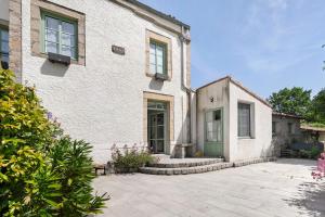 a house with a green door and a patio at Le Logis des Douves in Tiffauges