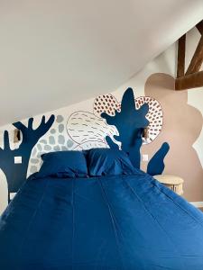 a bedroom with a blue bed with a blue comforter at l'Ocean in Dieppe