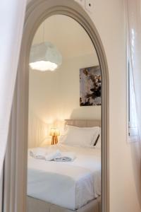a bedroom with a white bed and a mirror at Corfu Dream Apartment Chrysion in Glyfada
