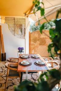a wooden table with plates and glasses on it at Corfu Dream Apartment Chrysion in Glyfada