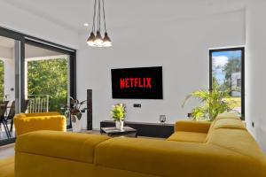 ein gelbes Sofa in einem Wohnzimmer mit einem Fernseher in der Unterkunft Vila Prisunca with jacuzzi & swimming pool in Pazin