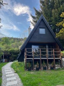 a house with a gambrel roof and a pathway at The Nest - Sauna and Hot Tub in Rynoltice