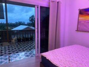 a pink room with a bed and a large window at Ocean View Tuggi Klong Prao in Klong Prao Beach