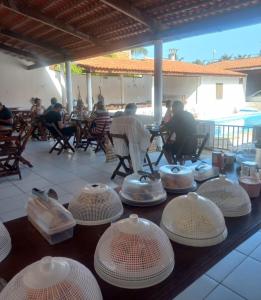 a group of people sitting at a table with hats on it at Pousada Vela dos Ventos in Praia de Moitas