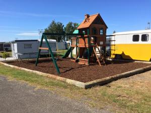 a playground with a slide and a small house at Motuoapa Bay Holiday Park in Turangi