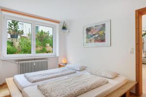 two beds in a room with two windows at Ferienwohnung Am Seebach, 80 Qm in Titisee-Neustadt