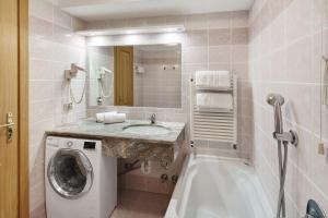 a bathroom with a sink and a washing machine at Appartamenti Lella in Vigo di Fassa +47 photos