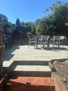 a patio with chairs and a table with an umbrella at The Village House in Findon