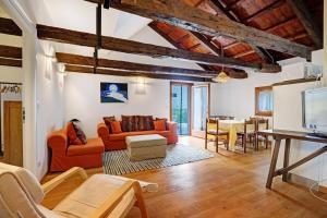 a living room with orange furniture and a table at Cozy Country Loft Oleandro in Chioggia