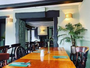a dining room with a wooden table and chairs at The Village House in Findon
