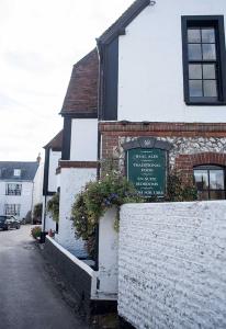 a building with a sign on the side of it at The Village House in Findon