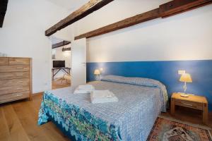 a bedroom with a bed and a blue wall at Cozy Country Loft Oleandro in Chioggia
