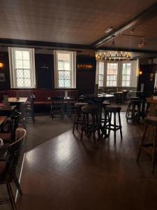 a dining room with tables and chairs and windows at The Village House in Findon