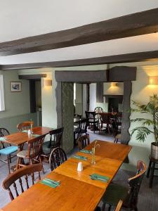 a dining room with wooden tables and chairs at The Village House in Findon +12 photos