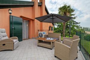 a patio with a table and chairs and an umbrella at Cozy Country Loft Oleandro in Chioggia