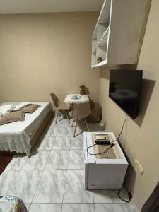 a bedroom with a bed and a table and a television at SUITE banheiro privativo & 2 QUARTOS banheiro social PERTO DO GERALDÃO,ARENA PERNAMBUCO,UNIVERSO, UFPE,AEROPORTO-AFOGADOS- RECIFE in Recife