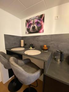 a bathroom with two sinks and a picture of a cat at Racoon Lounge in Bad Liebenstein +5 photos