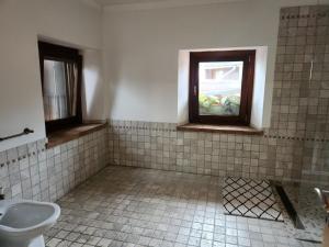 a bathroom with a toilet and a window at Il Pozzo dei Desideri Vintage in Spilimbergo +60 photos