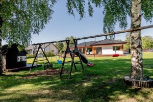 a park with two swings and a tree at Valgekodu Pesa in Papsaare