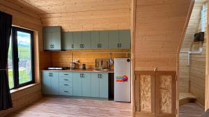 a kitchen with blue cabinets and a white refrigerator at Dsegh Eco Home in Dsegh