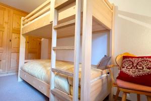 a wooden bunk bed in a room with a chair at Panorama Apartment Gotschnablick 1-6 Pers in Klosters