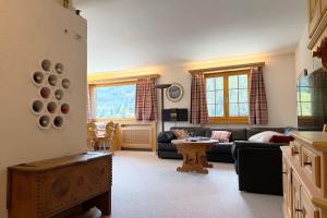 a living room with a couch and a table at Panorama Apartment Gotschnablick 1-6 Pers in Klosters