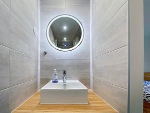 a bathroom with a white sink and a mirror at Proche Luxembourg et centrale Cattenom in Hettange-Grande
