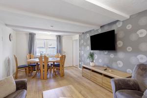 a living room with a table and a tv on a wall at Haus Schnettler mit Sauna in Bestwig