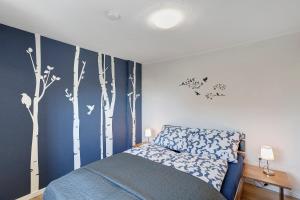 a bedroom with a bed with trees painted on the wall at Haus Schnettler mit Sauna in Bestwig