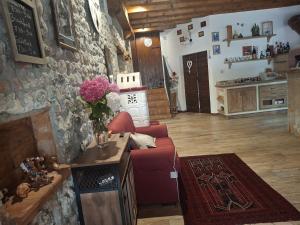a living room with a red couch and a stone wall at Il Pozzo dei Desideri Vintage in Spilimbergo