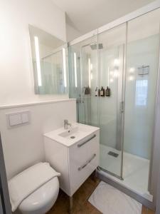 a white bathroom with a toilet and a shower at Brit Hotel Confort Deltour Mende in Mende +26 photos