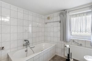 a white bathroom with a tub and a sink at Haus Schnettler mit Sauna in Bestwig +28 photos