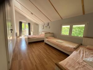 a room with two beds and a hallway with two windows at Пе́трови Вили in Ribarica +64 photos