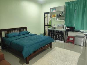 a bedroom with a bed with a blue comforter at Dikmad Studio Room Bukit Mentok, Kemaman in Cukai