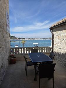 a table and chairs on a balcony with a view of the water at Guest house Jere Old Town in Rogoznica