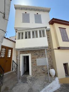 a white house with a door and a building at Samos Vista Azzurra 2 in Samos +11 photos